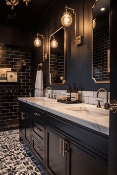 a black and white bathroom with two sinks, mirrors and lights on the wall above them