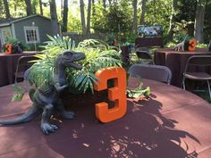 a dinosaur planter sitting on top of a table with the number 3 in front of it