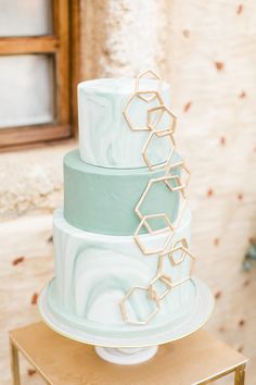 a three tiered cake with geometric designs on it