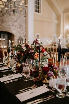 the table is set with wine glasses and place settings for guests to sit down at