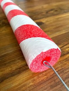 a red and white striped candy cane on a wooden table