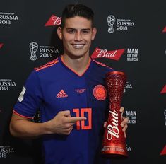 a man holding a trophy and posing for the camera