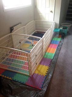 two white baby cribs sitting on top of a colorful mat in a room