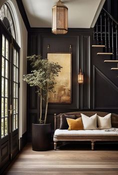 a living room filled with furniture and a plant on top of a wooden floor next to a stair case