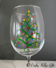 "This fun and colorful handpainted Christmas tree lights wineglass will make the perfect gift for someone for any occasion! If you are hosting a holiday party or dinner, these glasses make a great addition to your table. With free personalization, your guests will love that not only do they have a place setting but a take-home gift too! You can choose the color of the bottom stem by clicking on the drop-down menu.  Wineglasses hold 20oz Non-toxic paint is used and only applied to the outside of Diy Christmas Wine Glasses Paint, Holiday Wine Glass Painting, Christmas Wine Glass Painting Ideas, Painting Christmas Wine Glasses, Wine Glass Painting Ideas Easy Christmas, Painting Wine Glasses Christmas, Holiday Painted Wine Glasses, Glass Cup Painting Ideas Christmas, Christmas Painted Glasses