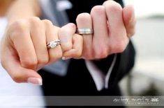 a man and woman holding hands with wedding rings on their fingers in front of them