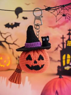 a crocheted pumpkin keychain hanging from a string