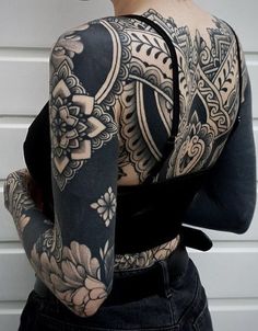 a woman with tattoos on her back and arms