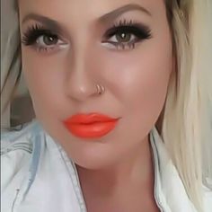 a woman with bright orange lipstick on her face