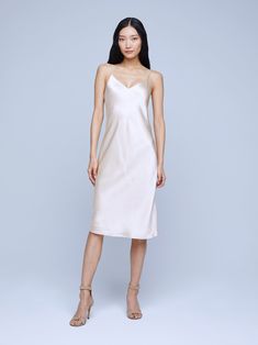 A body skimming slip dress crafted from a champagne silk charmeuse contours to your natural curves with a bias cut for an effortless allure. Adjustable spaghetti straps and a knee length hem balance a sexy silhouette with a soft v-neckline. Elegant Beige V-neck Slip Dress, Sleeveless Beige Slip Dress Bias Cut, Sleeveless Bias Cut Beige Slip Dress, Sleeveless Bias-cut Beige Slip Dress, Chic Cream Slip Dress With Spaghetti Straps, Silk Slip Dress With Delicate Straps For Date Night, Formal Cream Satin Slip Dress, Sleek Satin Knee-length Slip Dress, Sleek Knee-length Satin Slip Dress