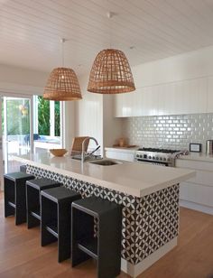 a kitchen with an island and stools in it