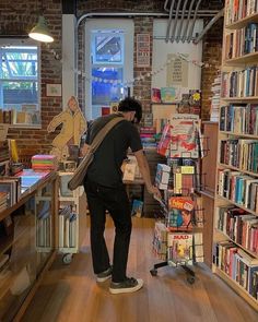 a man standing in front of a bookshelf filled with lots of different types of books