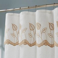 a white curtain with brown leaves on it