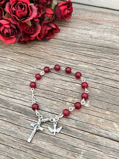 "Beautifully Handmade Rosary bracelet! Beads are 6mm polished (Ruby Red) Jade semi-precious stone, Cross is a 7/8\" silver St. Benedict crucifix, and mini medal is a 1/2\" mini medal with amazing details **Mini Medal Choices** 1. Blue Miraculous Mary 2. Miraculous Mary 3. Holy Spirit 4. 5 Way Cross 5. Holy Family / Holy Spirit 6. Guardian Angel / St. Michael Each one of my rosary bracelets starts its life as a spool of wire and a handful of beads. It is carefully assembled one link at a time so Handmade Rosary, Inspiration Pics, Stone Cross, Decade Rosary, Red Jade, Ruby Birthstone, St Benedict, Catholic Rosary, Rosary Bracelet