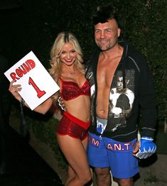 a man and woman dressed up in costumes posing for the camera with one holding a sign that says round 1