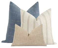 three blue and white pillows on a white background