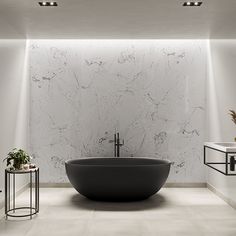 a bath tub sitting in the middle of a bathroom next to two tables and chairs