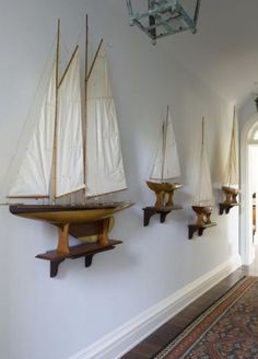 there are many shelves on the wall in this hallway that is decorated with sailboats