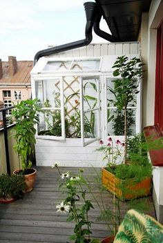 a balcony with potted plants on it and an awning over the porch area