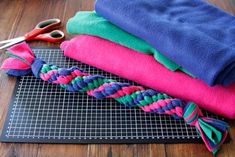 a pile of towels sitting on top of a cutting board next to scissors and yarn