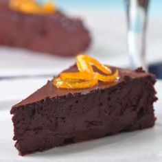 a piece of chocolate cake with orange peels on top and the rest of it