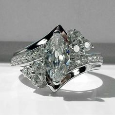 an engagement ring set with a pear shaped diamond in the center and side stones on each band