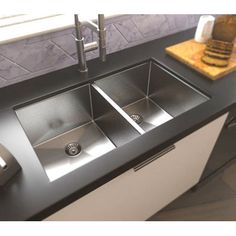 a kitchen sink with two faucets and soap dispenser