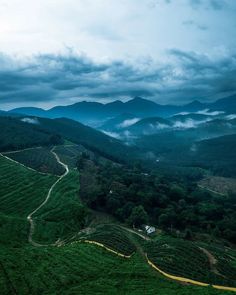 an aerial view of mountains and valleys with clouds in the sky over them on a cloudy day