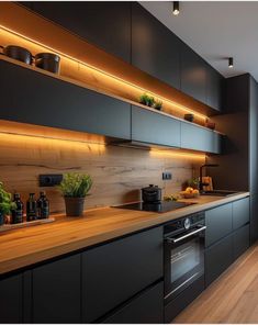 a kitchen with black cabinets and wooden counter tops, along with potted plants on the wall