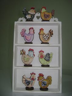 an assortment of chicken figurines on top of a white shelving unit against a green wall