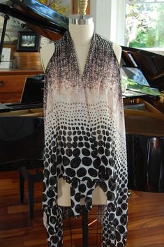 a black and white dress sitting on top of a mannequin next to a piano