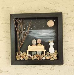 a small wooden frame with rocks and stones on it