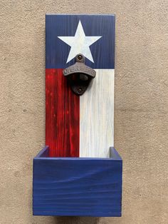 an american flag painted on the side of a building with a bottle opener attached to it