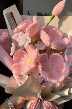 a bouquet of pink flowers is being held by someone