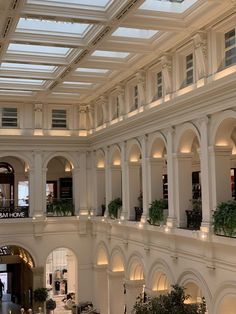 the interior of a large building with lots of windows and plants on the balconies