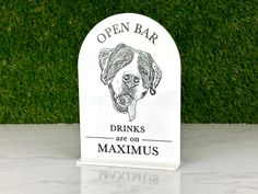 an open bar sign with a dog's head on it and the words drinks are on maximus