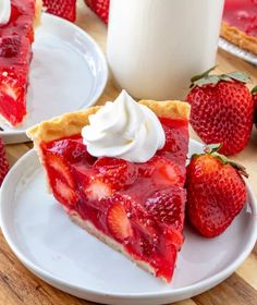 a slice of strawberry pie with whipped cream on top and strawberries in the background