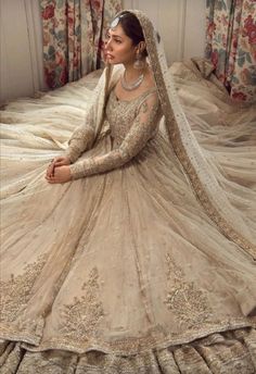 a woman sitting on top of a bed in a wedding dress