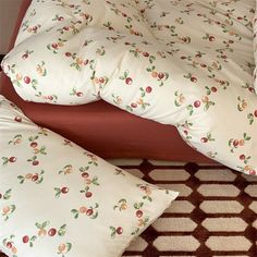 a bed with two pillows on top of it next to a red headboard and foot board