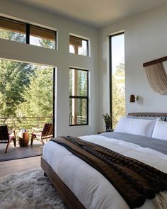 a large bed sitting in a bedroom next to two windows with sliding glass doors on each side