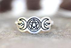 This listing is for one detailed sterling silver pentacle and moon phase ring with arrows. The unique witchy focal piece is hand stamped and fired onto sturdy 14 gauge sterling silver wire. Wear this ring solo or wear it stacked with several hammered bands for an edgier, bohemian style! Perfect gift for any witchy woman! - Choose your ring size and stacking options at checkout! - Triple Moon focal measures approximately 20mm by 9mm. - Ring band measures 1mm by 1mm - Made to Order: please see cur Moon Ring Tattoo, Spiritual Moon Phase Open Ring Jewelry, Mystical Silver Rings With Moon Phase, Celestial Silver Ring With Moon Phase, Symbolic Moon-shaped Adjustable Rings, Pentacle Ring, 9mm Ring, Witch Ring, Moon Phase Ring