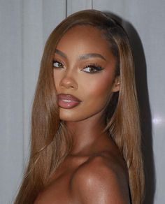 an image of a woman with long hair and brown eyeshadow posing for the camera