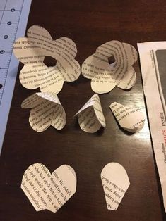 several pieces of paper cut out to look like hearts on a table next to a ruler