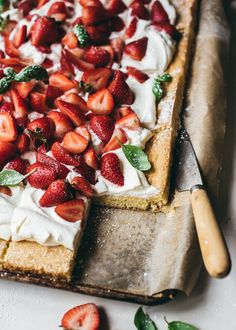 a strawberry shortbread with whipped cream and fresh strawberries on top, ready to be eaten