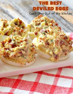 deviled eggs are sitting on a plate with red and white checkered tablecloth