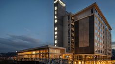 the hotel is lit up at night with lights on it's sides and windows