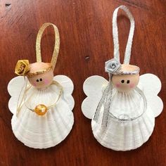 two angel ornaments are sitting on a table