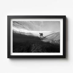 a black and white photo of a person on a surfboard riding a wave in the ocean