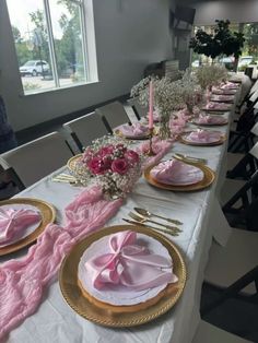 the table is set with pink napkins and place settings for two people to sit at