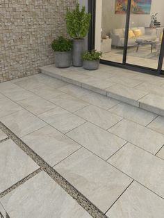 an outdoor patio with stone steps and potted plants